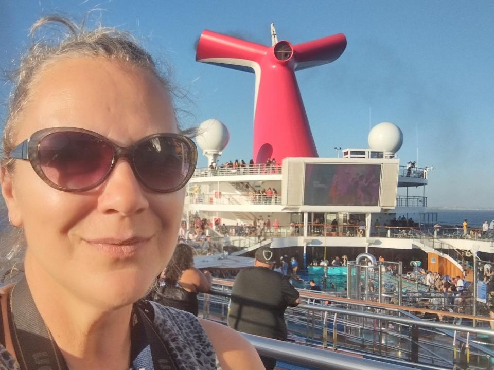 Woman wearing dark sunglasses taking a selfie with a cruise ship freelancer photo