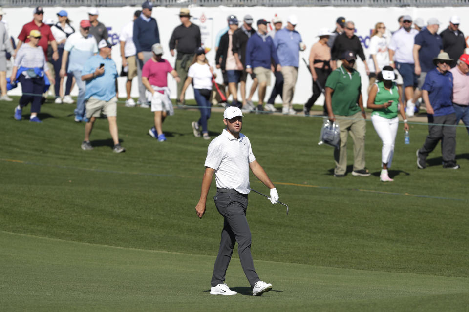 Scottie Scheffler, front, walks with the gallery to the 18th green during the first round of the Houston Open golf tournament Thursday, March, 28, 2024, in Houston. (AP Photo/Michael Wyke)