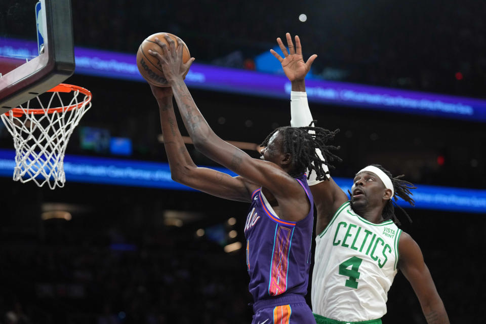 Phoenix Suns center Bol Bol (11) puts up a layup over Boston Celtics guard Jrue Holiday (4) during the first half at Footprint Center.