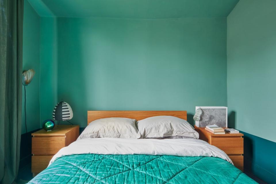 The bedroom is painted in shades of green, with wardrobes built by Holloway to save money (Juliet Murphy)