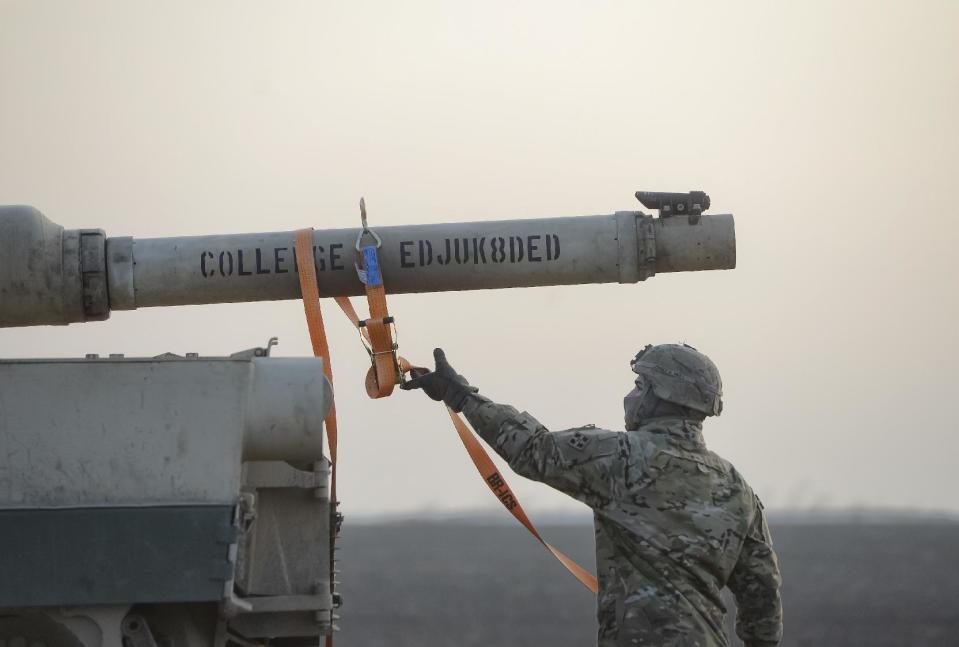 A serviceman of the "Fighting Eagles" 1st Battalion, 8th Infantry Regiment, works on a tank that arrived via train to the US base in Mihail Kogalniceanu, eastern Romania, Tuesday, Feb. 14, 2017. Five hundred U.S. troops began to arrive in a Black Sea port in Romania with tanks and hardware to bolster defense in this East European NATO nation. (AP Photo/Andreea Alexandru)