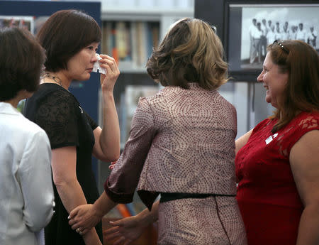 Akie Abe, wife of Japan's Prime Minister Shinzo Abe, is comforted by Pastor Lauren Merritt and Kristy O'Brien, as she gets emotional looking at an exhibition about the Japanese company responsible for clearing Darwin Harbour of shipwrecks after World War II, during a tour at the Darwin Uniting Memorial Church in Darwin, Australia, November 16, 2018. Rick Rycroft/Pool via REUTERS