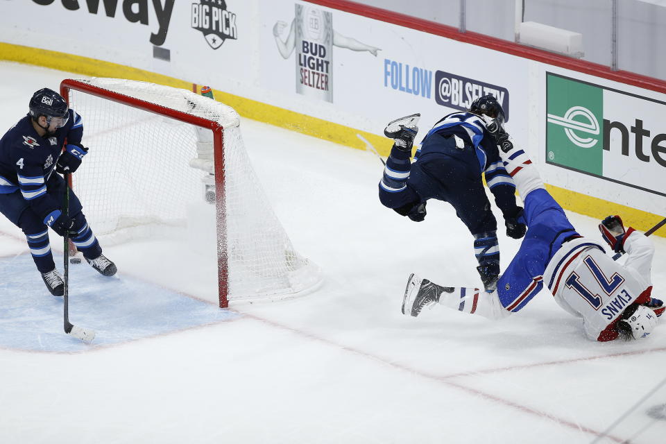 Winnipeg Jets' Mark Scheifele (55) hits Montreal Canadiens' Jake Evans (71) after Evans scored an empty-net goal during the third period of Game 1 of an NHL hockey Stanley Cup second-round playoff series Wednesday, June 2, 2021, in Winnipeg, Manitoba. (John Woods/The Canadian Press via AP)