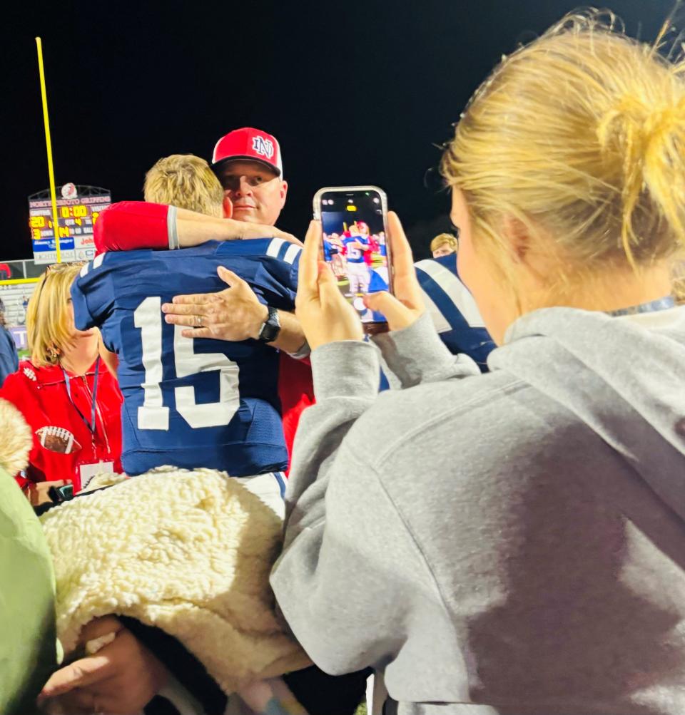 North DeSoto quarterback Luke Delafield gets a hug from his father following Friday's LHSAA Non-Select Division II semifinal contest while his mother captures the moment.