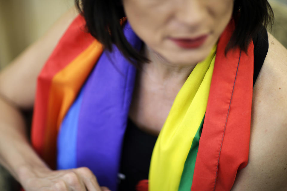 Vladimir Luxuria, a former Communist lawmaker in the Italian parliament and prominent crusader for transgender rights, wears a rainbow scarf while sitting for an interview, Monday, Feb. 17, 2014, in central Sochi, Russia, home of the 2014 Winter Olympics. Luxuria said she was detained by police at the Olympics after being stopped while carrying a rainbow flag that read in Russian: "Gay is OK." Police on Monday denied this happened. (AP Photo/David Goldman)