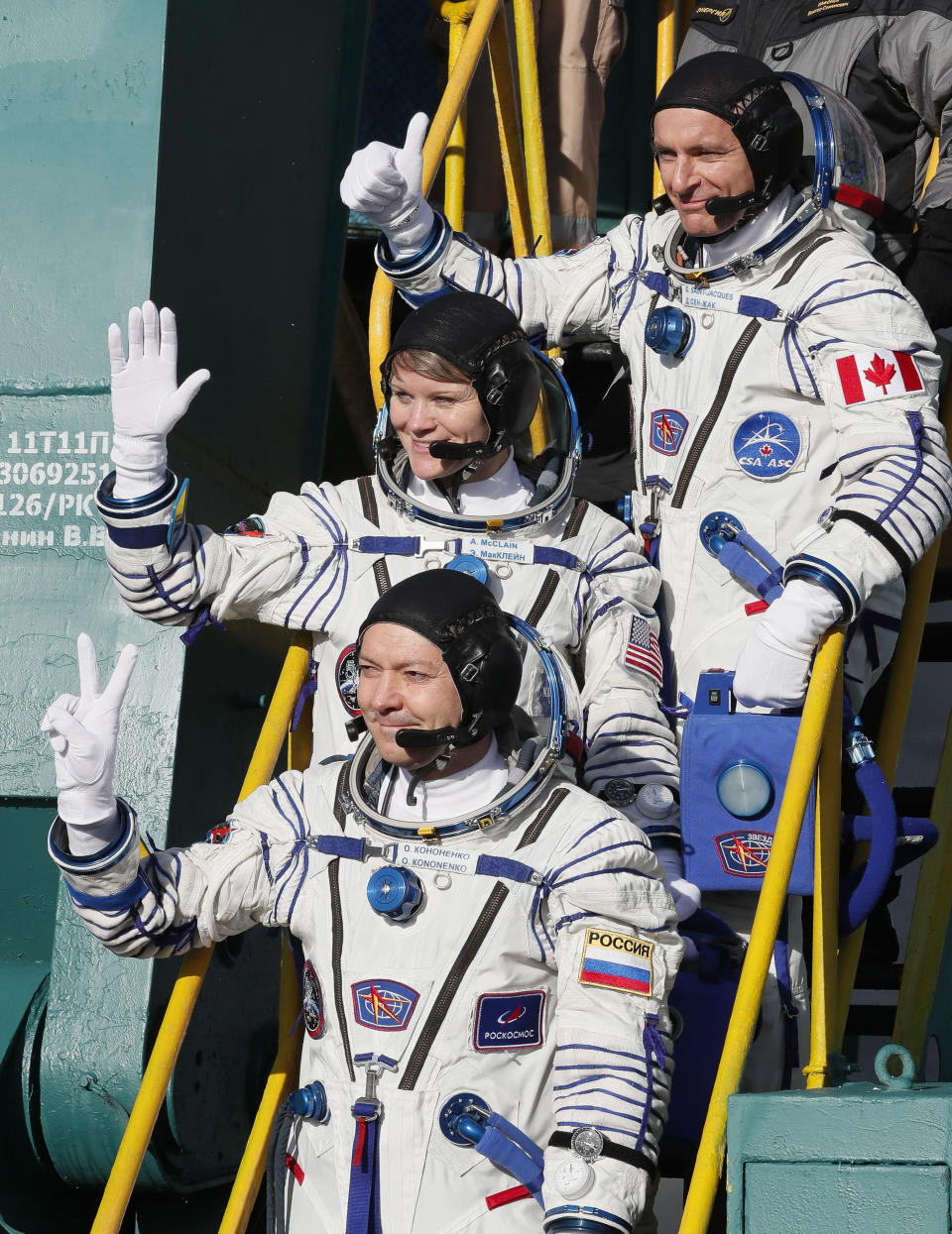 U.S. astronaut Anne McClain, centre, Russian cosmonaut Оleg Kononenko, bottom, and CSA astronaut David Saint Jacques, crew members of the mission to the International Space Station, ISS, wave as they board the rocket prior to the launch of Soyuz-FG rocket at the Russian leased Baikonur cosmodrome, Kazakhstan, Monday, Dec. 3, 2018. (AP Photo/Shamil Zhumatov, Pool)