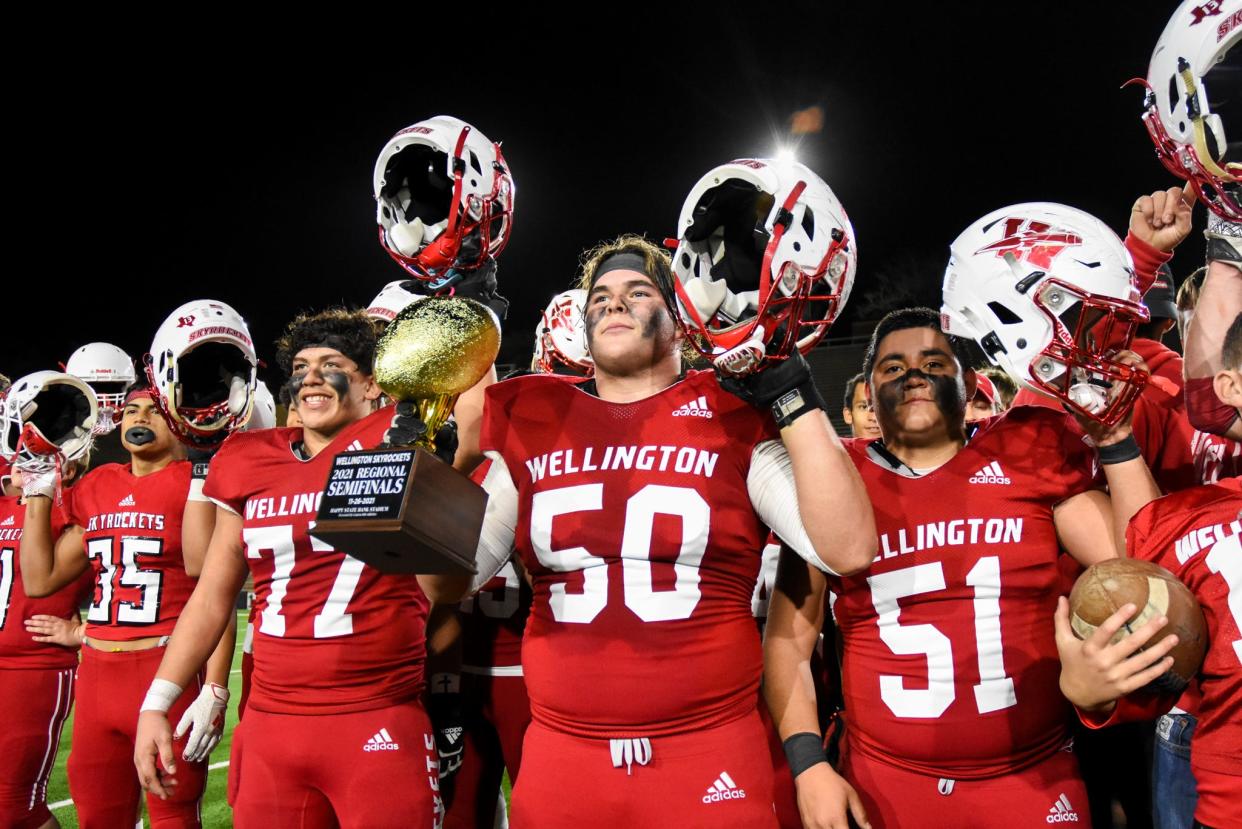 Blake Strickland (50) holds the regional semifinal championship trophy after Wellington's 36-8 win over Gruver in the 2A DII Region 1 semifinal on Nov. 26, 2021 at Happy State Bank Stadium in Canyon.