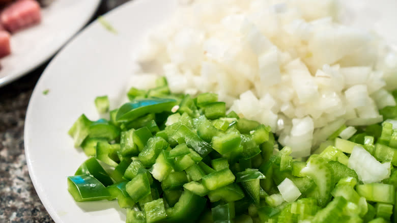 Plate of diced white onion, celery and green bell peppers
