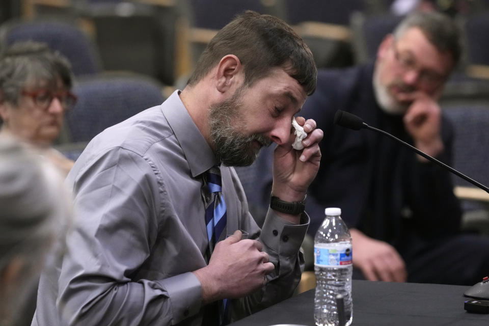 Sean Hodgson, a member of the U.S. Army Reserve, wipes tears while recalling the moment he heard about the mass shooting, Thursday, April 25, 2024, in Augusta, Maine, during a hearing of the independent commission investigating the law enforcement response to the mass shooting in Lewiston, Maine. (AP Photo/Robert F. Bukaty)