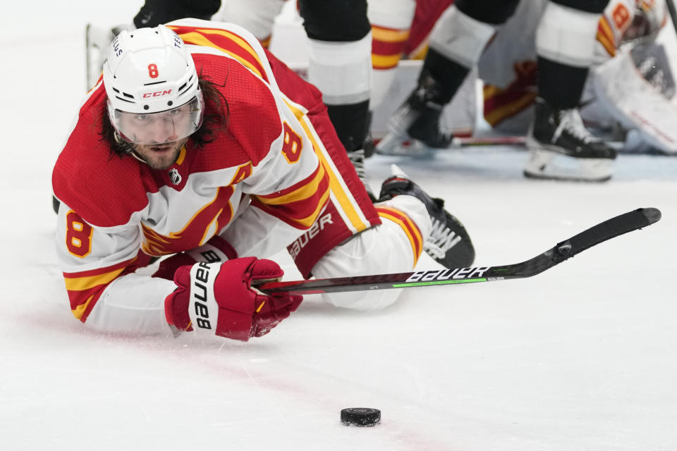 Calgary Flames defenseman Chris Tanev (8) falls while reaching for the puck during the second period of an NHL hockey game against the Los Angeles Kings Thursday, Dec. 22, 2022, in Los Angeles. (AP Photo/Ashley Landis)