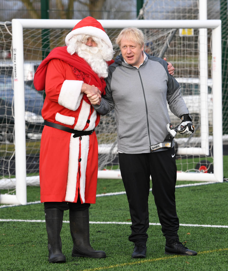 Prime Minister Boris Johnson with a man dressed as Father Christmas before a football match between Hazel Grove Utd and Poynton Jnr u10s in the Cheshire Girls football league in Cheadle Hume, Cheshire, while on the election campaign trail.