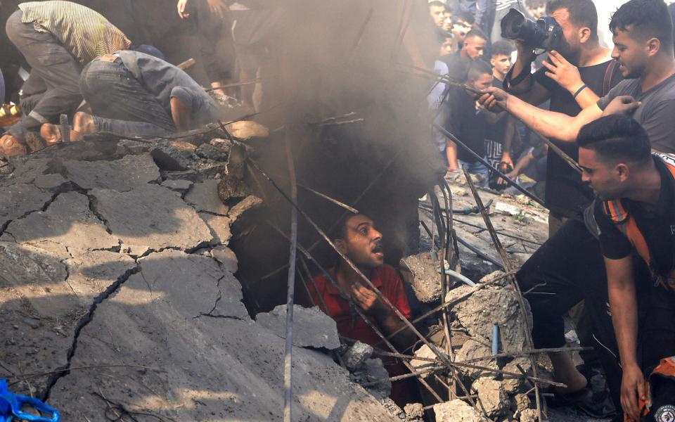 Palestinians check the rubble of a building in Khan Yunis