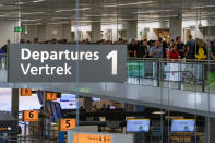 Travelers wait in long lines to check in and board flights at Amsterdam's Schiphol Airport, Netherlands, Tuesday, June 21, 2022. The airport is reining in flight departures over its busy summer period because shortages of security staff mean it cannot cope with the high demand as many families take to the skies for the first time since the coronavirus pandemic has eased. The decision is likely to affect the vacation plans of thousands of travelers each day, the airport's CEO said.(AP Photo/Peter Dejong)