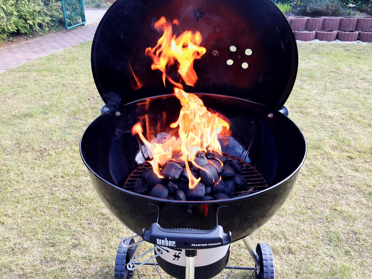 charcoal grill set up in a backyard (Getty Images stock)