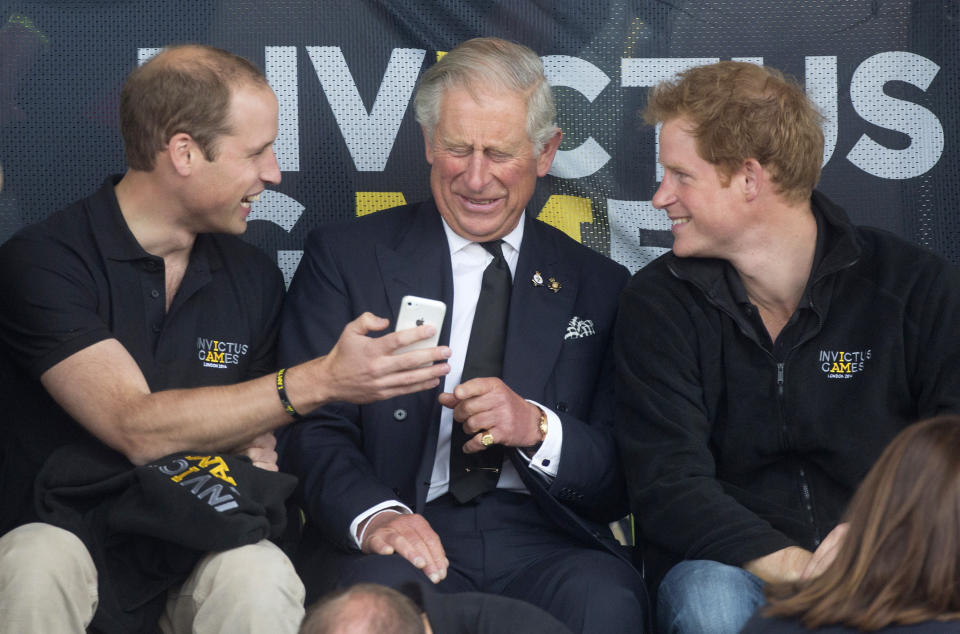 Los príncipes británicos William (izquierda), Charles (C) y Harry miran un teléfono móvil durante los Invictus Games en el Lee Valley Athletics Centre en el norte de Londres el 11 de septiembre de 2014. REUTERS / Neil Hall