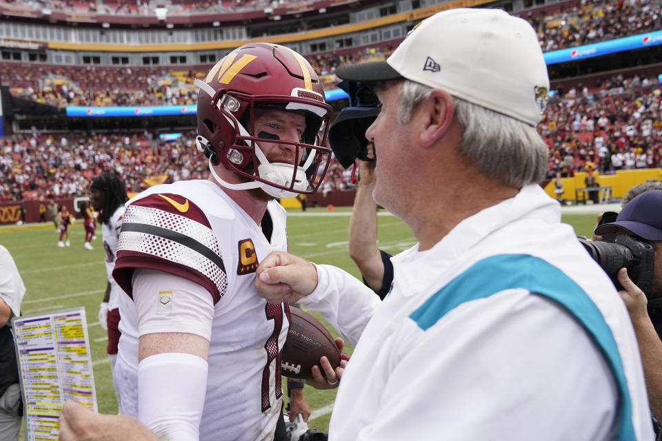 Jacksonville Jaguars head coach Doug Pederson meets with Washington Commanders quarterback Carson Wentz (11) at the end of an NFL football game, Sunday, Sept. 11, 2022, in Landover, Md. Washington won 28-22. (AP Photo/Patrick Semansky)