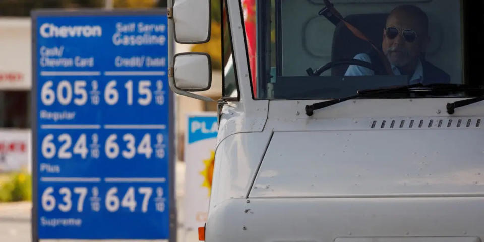 Ein US-Postangestellter legt seinen Sicherheitsgurt an, nachdem er sein Fahrzeug an einer Tankstelle in Garden Grove, Kalifornien, USA, am 29. März 2022 aufgetankt hat. - Copyright: Mike Blake/Reuters