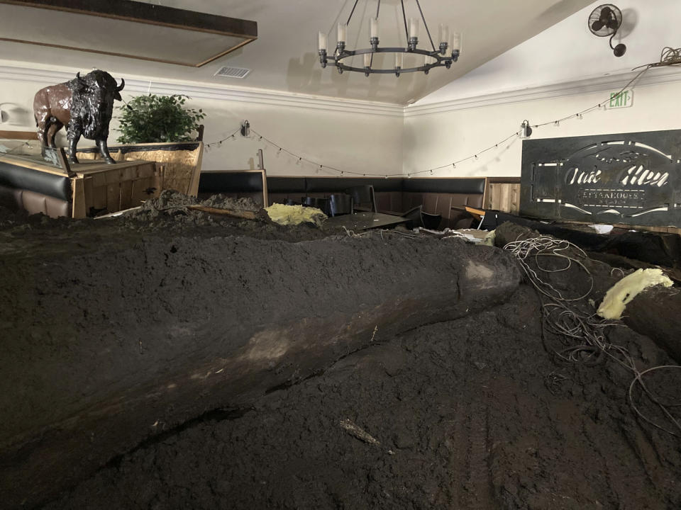 FILE - Extensive damage from a slow-moving black river of sludge is seen inside the Oak Glen Steakhouse and Saloon on Wednesday, Sept. 14, 2022, in Oak Glen, Calif. A woman who went missing after flash floods unleashed mudslides that swept through her town in the Southern California mountains earlier this week has been found dead under a pile of mud, rocks and other debris, authorities said Friday, Sept. 16, 2022. (AP Photo/Amy Taxin, File)