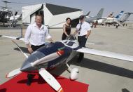 Air Race1 CEO, Jeff Zaltman, left, poses with his colleagues next to their electric aircraft during the opening day of Dubai Airshow in Dubai, United Arab Emirates, Sunday, Nov. 17, 2019. The biennial Dubai Airshow has opened as major Gulf airlines reign back big-ticket purchases after a staggering $140 billion in new orders were announced at the 2013 show before global oil prices collapsed. (AP Photo/Kamran Jebreili)