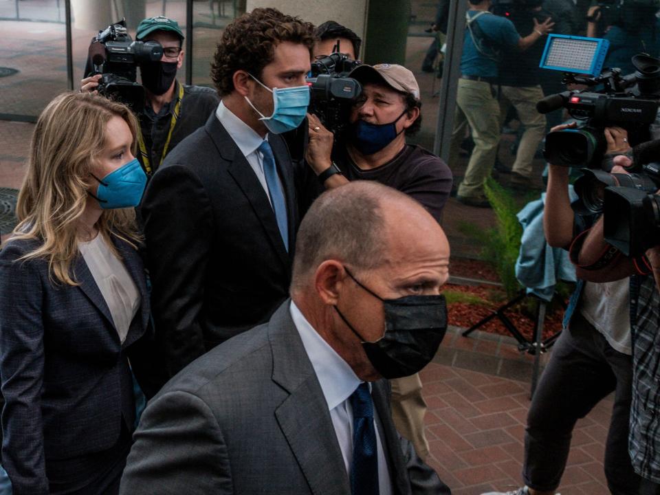 William L. Evans, Billy Evans' father, seen in a black mask walking alongside Elizabeth Holmes, her mother Noel Holmes, and Billy Evans to court