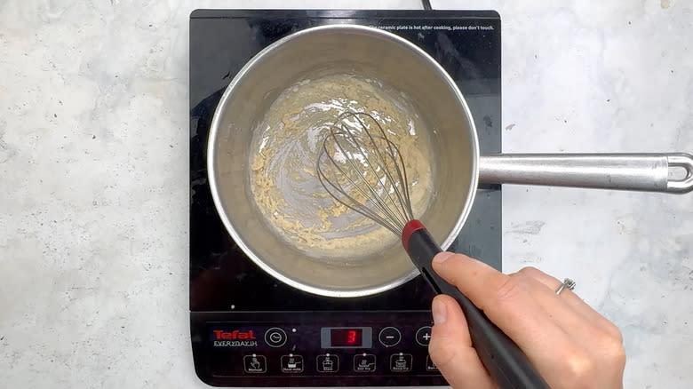 hand whisking flour in saucepan