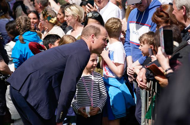<p>Andrew Matthews-WPA Pool/Getty</p> Prince William, Prince of Wales speaks to people during a walkabout in Windsor on May 7.