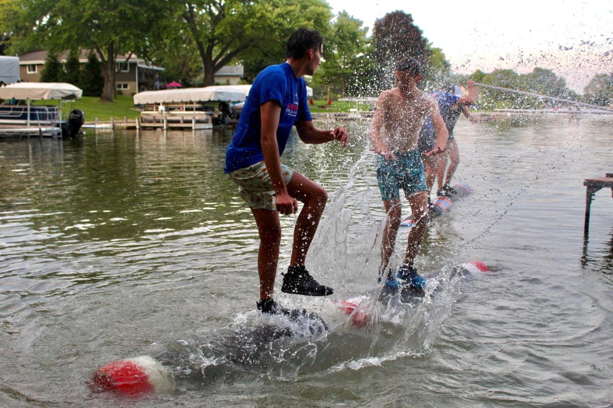 Sam Polentini (left) splashes Joey Polentini during a practice on Upper Oconomowoc Lake. Splashing is allowed in logrolling competitions.