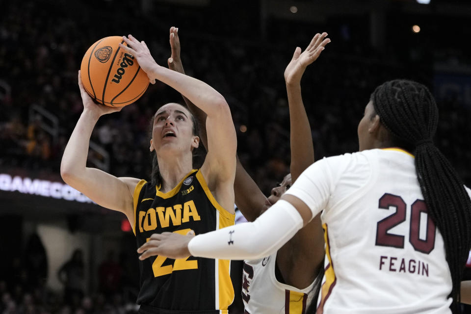 Iowa guard Caitlin Clark (22) shoots over South Carolina forward Sania Feagin (20) during the second half of the Final Four college basketball championship game in the women's NCAA Tournament, Sunday, April 7, 2024, in Cleveland. (AP Photo/Morry Gash)
