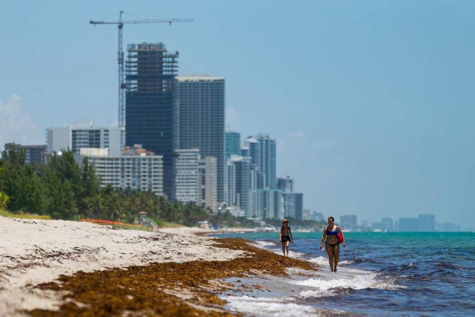 Visitors make their way south down Golden Beach toward Sunny Isles Beach. The town of Golden Beach says the sandy beach is privately owned by homeowners and visitors can only traverse it along the water’s edge.