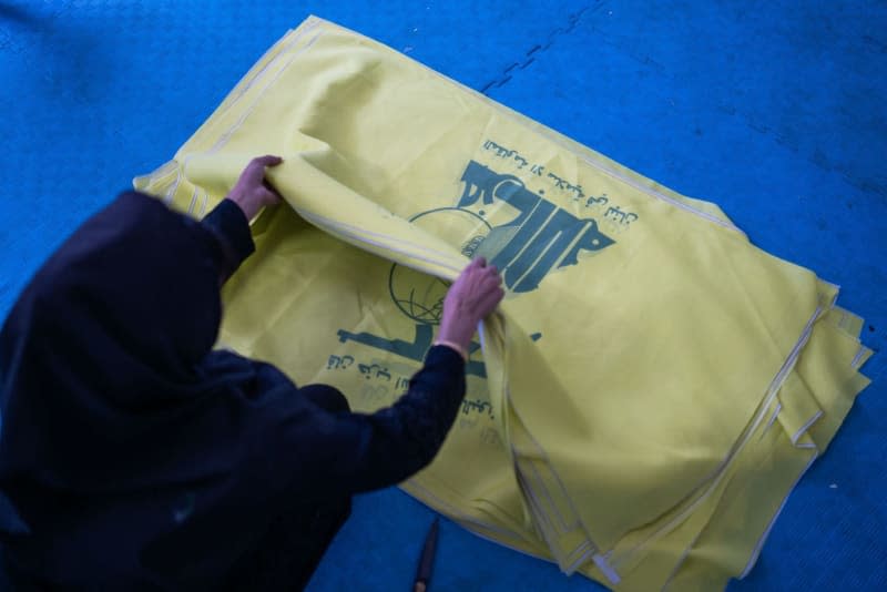 A woman sorts flags of the Lebanese Hezbollah militia in a factory. Lebanon's pro-Iranian Hezbollah militia said on Thursday it has only shown a fraction of its capabilities since the outbreak of the Gaza war and the violent fighting on the border with Israel, as a US special envoy in Beirut urged a diplomatic solution. Arne Immanuel Bänsch/dpa