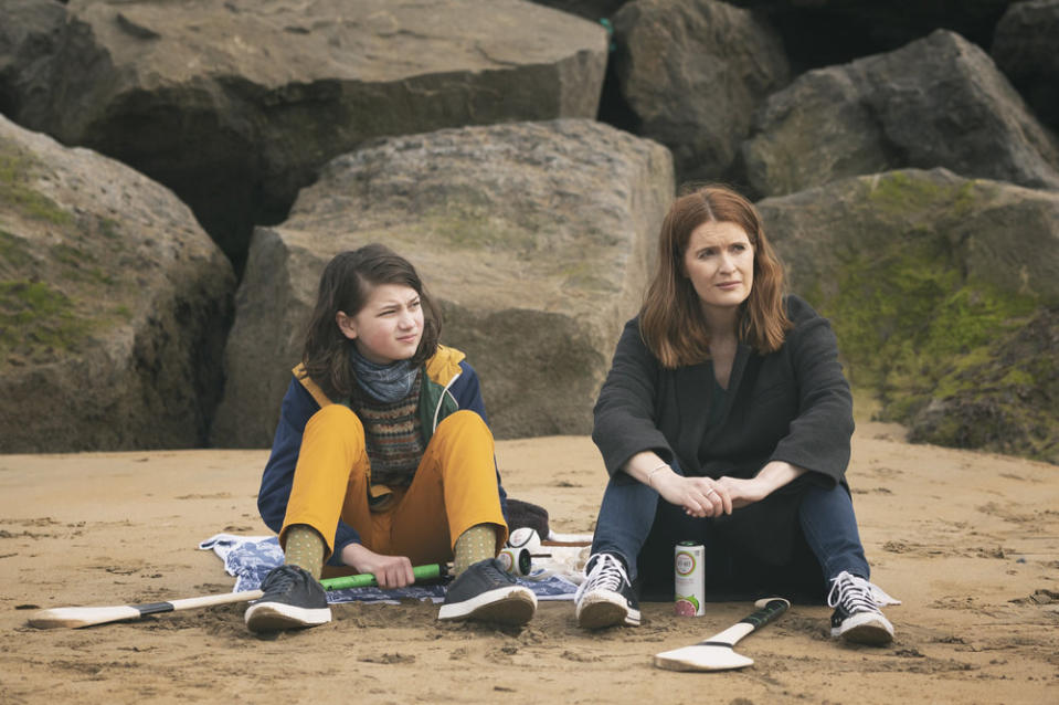 Elijah O'Sullivan and Justine Mitchell sit on a beach