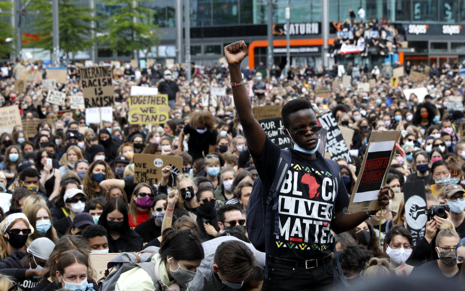 A man raises his fist as people gather in Berlin, Germany, Saturday, June 6, 2020, to protest against the recent death of George Floyd by police officers in Minneapolis, that has led to protests in many countries and across the US. (AP Photo/Markus Schreiber)