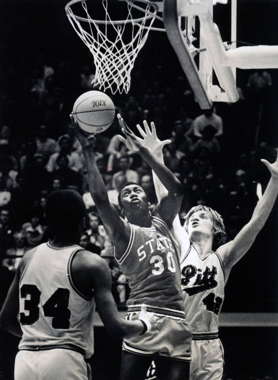 NC State’s Phil Spence dries to the basket against Pitt’s Bill Knight (34) and Mickey Martin (42) in the NCAA Eastern Regionals in Raeligh, NC March 19, 1974.