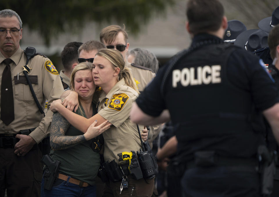 Law enforcement members comfort each other after St. Croix County Deputy Kaitie Leising's body was carried into a Baldwin, Wis., funeral home Sunday afternoon, May 7, 2023. Leising was shot and killed during a traffic stop Saturday. (Jeff Wheeler/Star Tribune via AP)