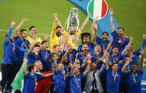 Italy celebrate with their trophy after defeating England in a penalty shootout at the Euro 2020 soccer championship final at Wembley stadium in London, Sunday, July 11, 2021. (John Sibley/Pool Photo via AP)