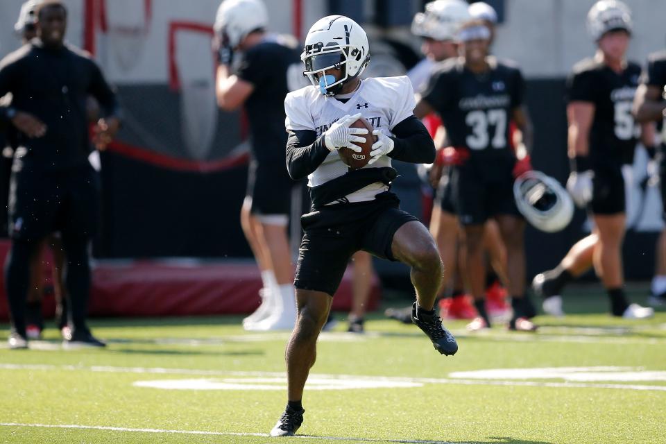 Bearcats receiver Tre Tucker (1) catches a pass during the first day of preseason training camp at the University of Cincinnati’s Sheakley Athletic Complex in Cincinnati on Wednesday, Aug. 3, 2022.