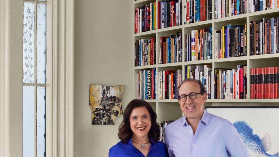 author and homeowner ingrid abramovitch with her husband in a room with built in shelving and lovely pocket doors