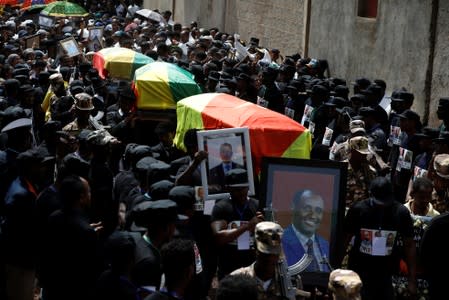 Mourners carry the coffin of Amhara president Mekonnen and two other officials during their funeral in the town of Bahir Dar