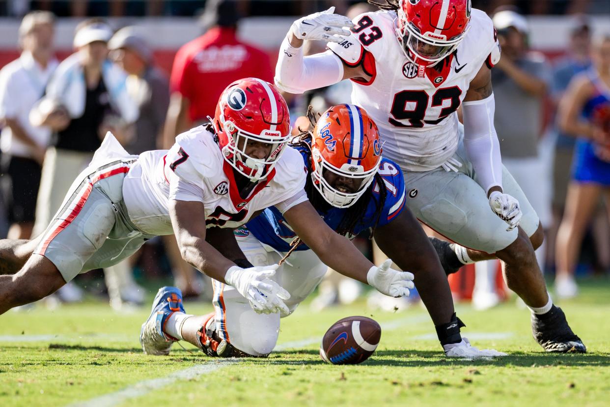 Georgia Bulldogs linebacker Marvin Jones Jr. (7) battles with Florida Gators offensive lineman Damieon George Jr. (76) and Georgia Bulldogs defensive lineman Tyrion Ingram-Dawkins (93) for the loose ball during the first half at Everbank Stadium in Jacksonville, FL on Saturday, October 28, 2023. [Matt Pendleton/Gainesville Sun]