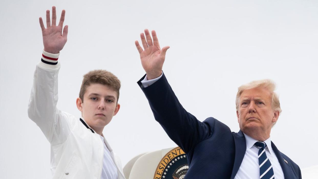 barron trump and donald trump waving as they prepare to board air force one