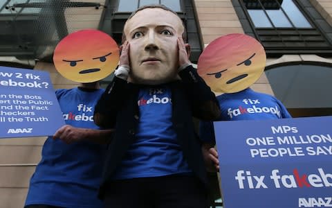 A protest outside of Portcullis house where Mr Schroepfer was questioned - Credit: AFP