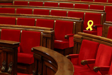 A yellow ribbon is seen in the seat of dismissed Catalan Vice President Oriol Junqueras, currently in custody awaiting trial on charges of sedition, rebellion and misappropriation of public funds, before the start of the first session of Catalan Parliament after the regional elections in Barcelona, Spain, January 17, 2018. REUTERS/Albert Gea
