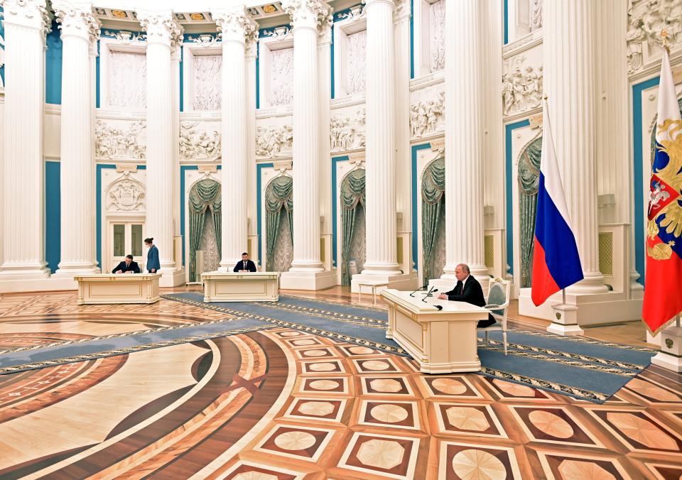 Russian President Vladimir Putin, right, signs a document recognizing the independence of separatist regions in eastern Ukraine with Denis Pushilin, the leader of the Donetsk People's Republic controlled by Russia-backed separatistsm center, and Leonid Pasechnik, acting leader of self-proclaimed Luhansk People's Republics, left, in the Kremlin in Moscow, Russia, Monday, Feb. 21, 2022. Russia's Putin has recognized the independence of separatist regions in eastern Ukraine, raising tensions with West. (Alexei Nikolsky, Sputnik, Kremlin Pool Photo via AP)