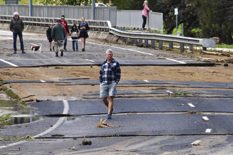 Residents walk through the flood damaged roads in the town of Canowindra, in the Central West New South Wales, Australia, Tuesday, Nov. 15, 2022. A rare third consecutive La Niña weather pattern, which is associated with above-average rainfall in eastern Australia, has created a flooding emergency across large swathes of New South Wales that has lasted for two months.(Murray McCloskey/AAP Image via AP)