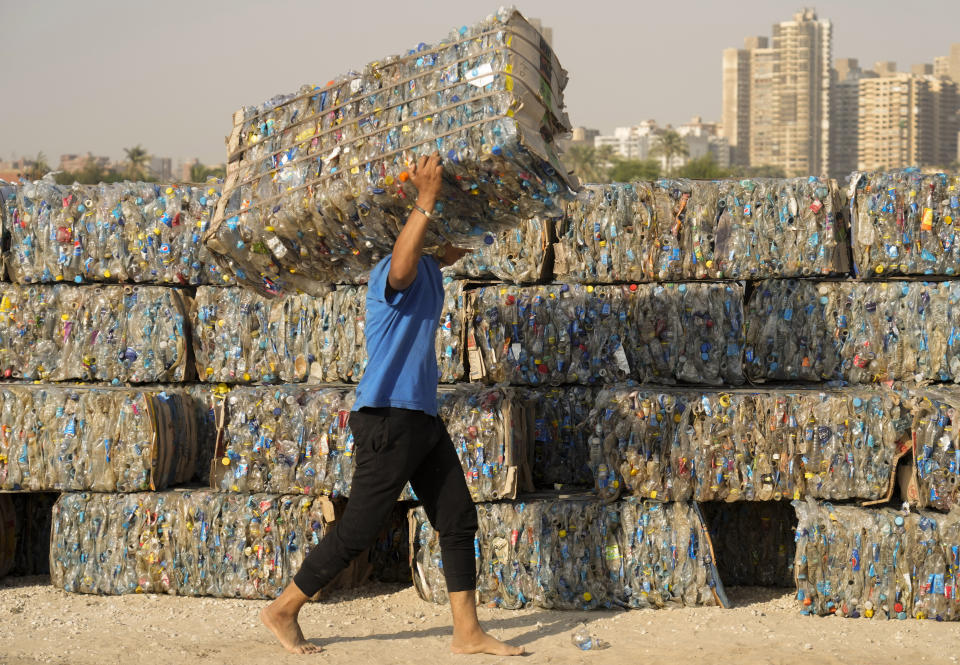 FILE - "Verynile" initiative worker carries compressed plastic bottles which were collected by volunteers and fishermen from the Nile to build a Plastic Pyramid ahead of World Cleanup Day in Cairo, Egypt on Sept. 15, 2022. The pyramid aiming to raise awareness on plastic pollution in the Nile. The U.N. climate summit is back in Africa after six years and four consecutive Europe-based conferences. The conference — known as COP27 — will be held in the resort city of Sharm el-Sheikh in Egypt. (AP Photo/Amr Nabil, File)