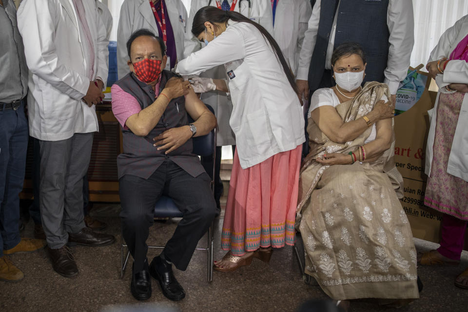 Indian Health Minister Harsh Vardhan is administered the COVAXIN vaccine, developed by Indian company Bharat Biotech, with his wife Nutan Goel sitting next to him after receiving her shot at a private hospital in New Delhi, India, Tuesday, March 2, 2021. India is expanding its coronavirus vaccination drive beyond health care and front-line workers, offering the shots to older people and those with medical conditions that put them at risk. (AP Photo/Altaf Qadri)