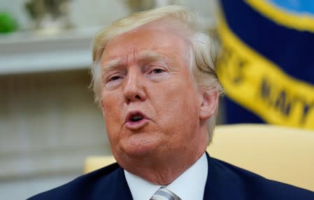 U.S. President Donald Trump answers reporters questions in the Oval office of the White House In Washington