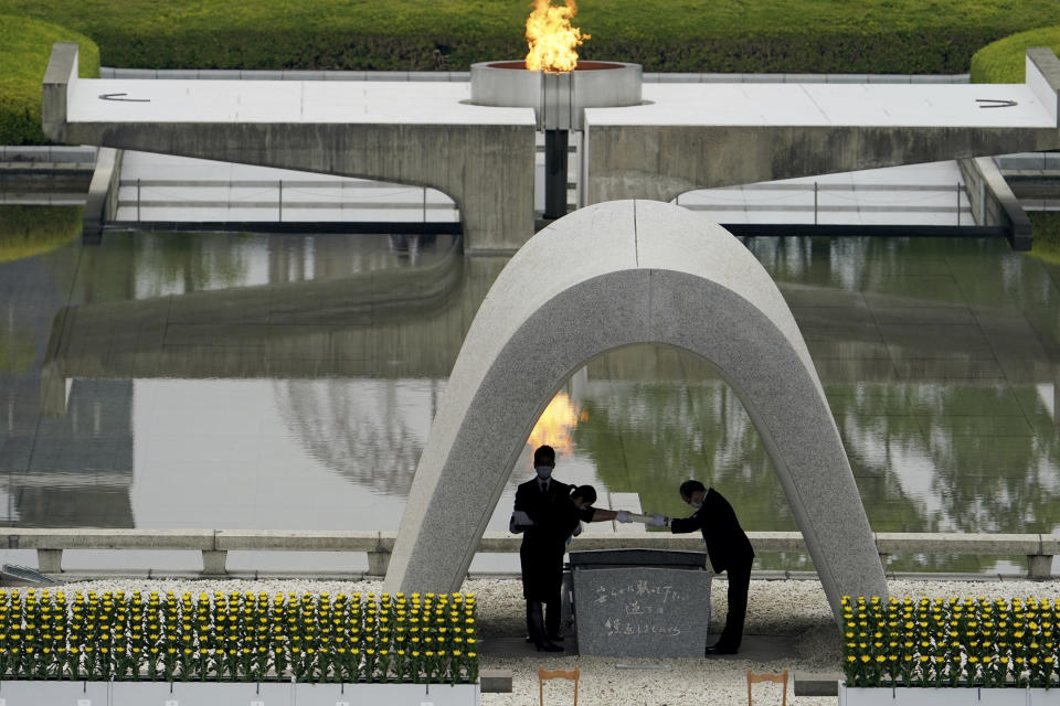 Kazumi Matsui, right, mayor of Hiroshima, and the family of the deceased bow before they place the victims list of the Atomic Bomb at Hiroshima Memorial Cenotaph during the ceremony to mark the 75th anniversary of the bombing at the Hiroshima Peace Memorial Park Thursday, Aug. 6, 2020, in Hiroshima, western Japan. (AP Photo/Eugene Hoshiko)