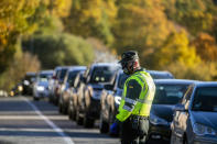 Guardia Civil officers stop vehicles at a checkpoint in Somosierra, Spain, Friday, Oct. 30, 2020. All Spanish regions except for the Canary Islands are already implementing overnight curfews to reduce social meetings and parties that could spread the virus. (AP Photo/Manu Fernandez)