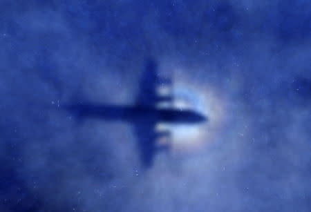 The shadow of a Royal New Zealand Air Force (RNZAF) P-3 Orion maritime search aircraft is seen on low-level cloud, as it flies over the southern Indian Ocean looking for missing Malaysia Airlines Flight MH370, in this March 31, 2014 file photo. REUTERS/Rob Griffith/Pool/Files